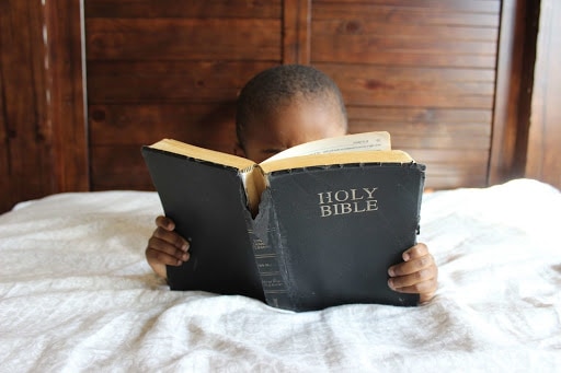 Boy reading Bible about tithing and offering